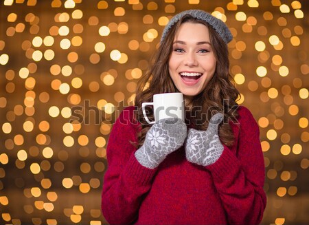 Closeup of cup with candy cane holded by smiling female  Stock photo © deandrobot