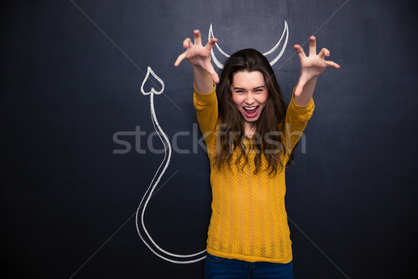 Kiált nő ördög áll tábla fiatal nő Stock fotó © deandrobot