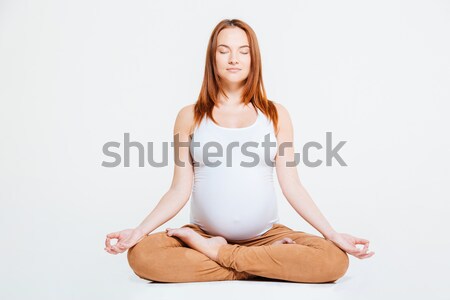 Terhes nő meditál lótusz pozició izolált fehér Stock fotó © deandrobot