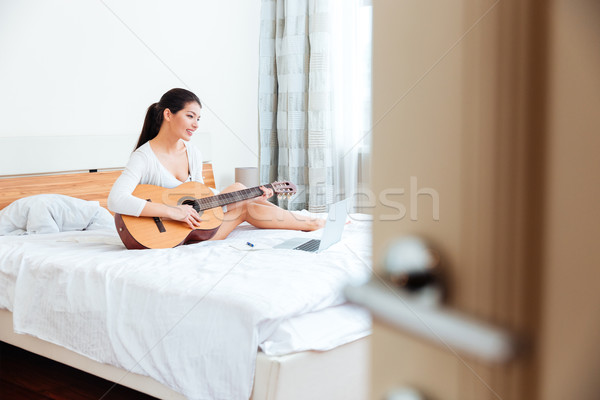 Woman playing records on guitar supported by laptop computer Stock photo © deandrobot