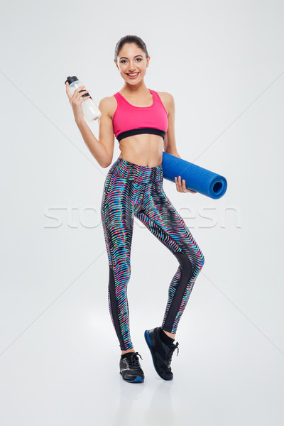 Stock photo: Smiling woman holding yoga mat and shaker
