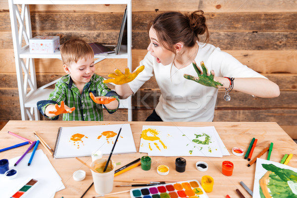 Mother and son making prints by painted hands on paper  Stock photo © deandrobot