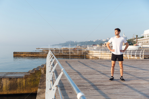 Confident young spotrsman standing on pier Stock photo © deandrobot