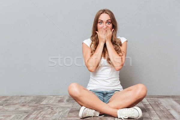Fiatal nő befogja száját pálma padló ül izolált Stock fotó © deandrobot