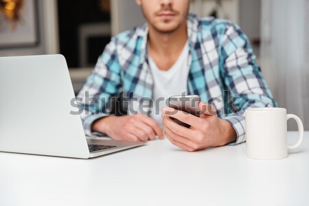 Cropped image of man writing message on phone Stock photo © deandrobot