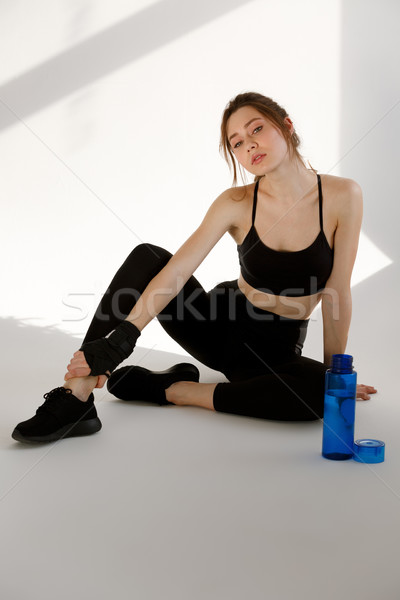 Concentrated young serious sports woman with bottle of water Stock photo © deandrobot