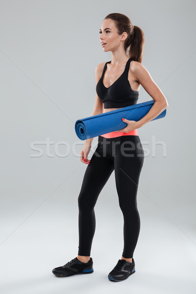 Full length image of surprised fitness woman with fitness mat Stock photo © deandrobot