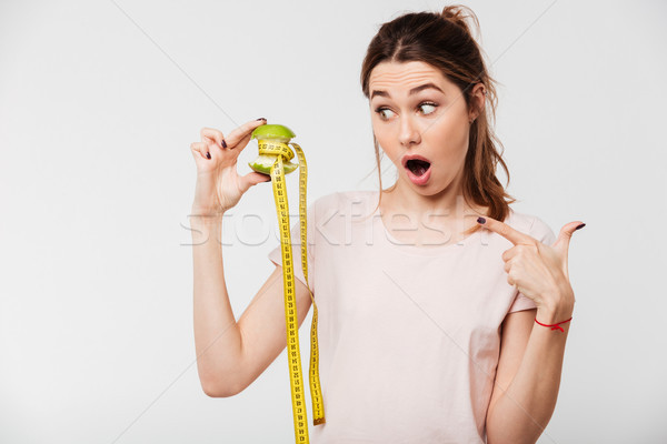 Portrait of an excited pretty girl holding half eaten apple Stock photo © deandrobot