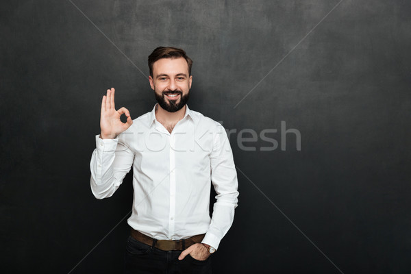 Photo of unshaved guy in office smiling and gesturing with OK si Stock photo © deandrobot