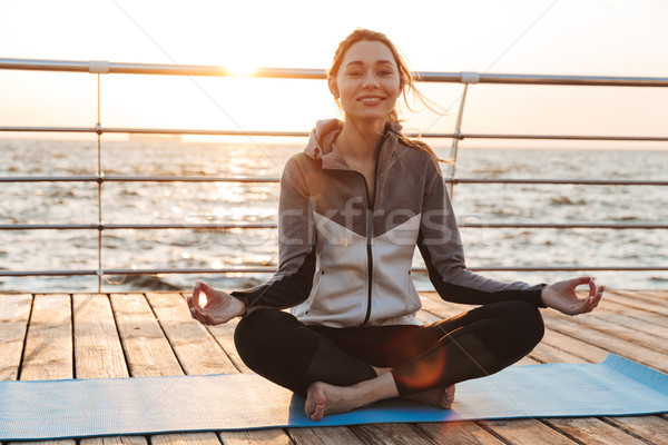 Boldog fiatal lány meditál ül fitnessz víz Stock fotó © deandrobot