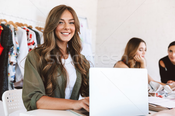 Three cheerful young women clothes designers Stock photo © deandrobot