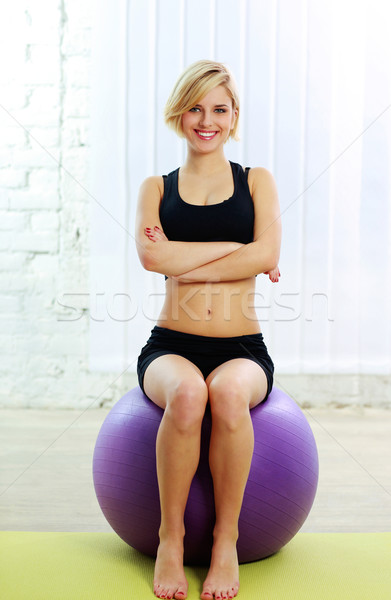 Young cheerful fit woman sitting on the fitball Stock photo © deandrobot