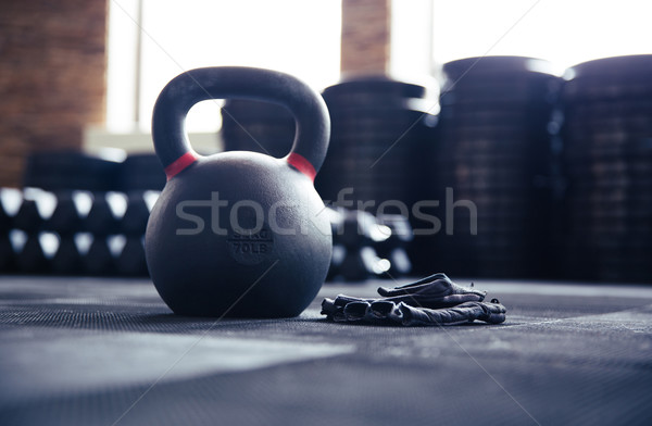 Closeup image of a kettle ball and sports gloves Stock photo © deandrobot