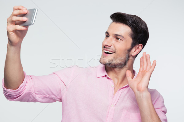 Happy businessman showing greeting sign on smartphone Stock photo © deandrobot