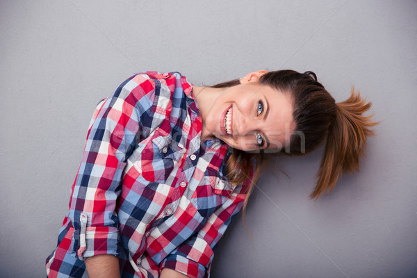 Cute woman with ponytail looking at camera Stock photo © deandrobot
