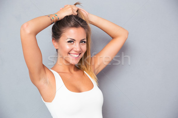 Cheerful woman holding her ponytail Stock photo © deandrobot