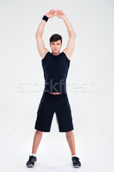 Portrait of a athletic man doing warm up exercises  Stock photo © deandrobot