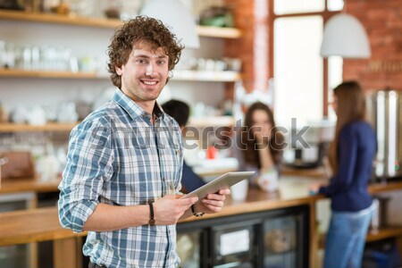 Derűs vonzó fiatal fürtös férfi laptopot használ Stock fotó © deandrobot