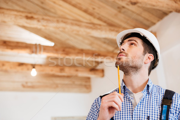 Close-up portrait of a builder examining his working place Stock photo © deandrobot