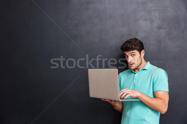 Foto stock: Assustado · suspeito · moço · em · pé · laptop · quadro-negro