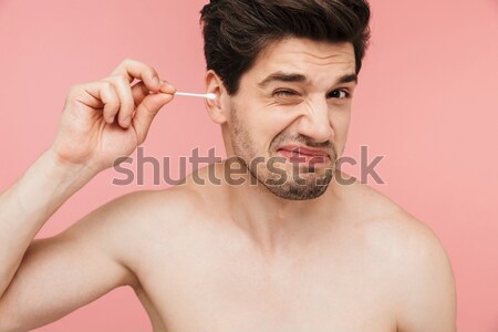 Hansome serious young man removing eyebrow hairs with tweezers Stock photo © deandrobot