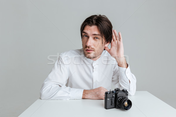 Young man which overhears conversation while sitting at the table Stock photo © deandrobot