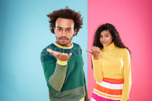 Stock photo: Beautiful african woman pointing on her boyfriend who sending kiss