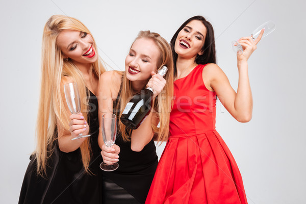 Három nyugodt vonzó fiatal nők iszik pezsgő Stock fotó © deandrobot