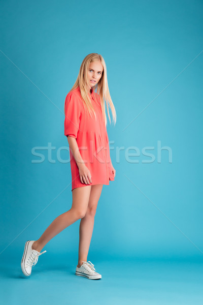 Young woman in red dress standing and looking at camera Stock photo © deandrobot