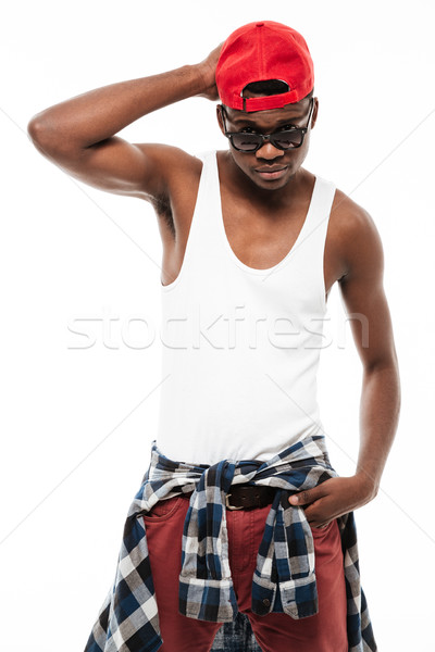 Confident african american young man in red cap and sunglasses Stock photo © deandrobot
