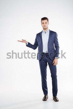 Full length portrait man holding invisible copyspace on the pound Stock photo © deandrobot