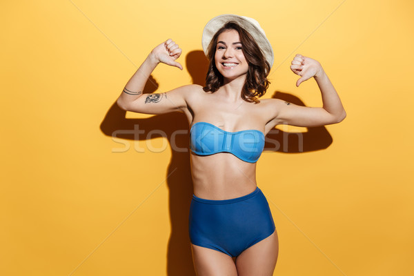 Boldog fiatal nő fürdőruha mutat hüvelykujjak lefelé Stock fotó © deandrobot