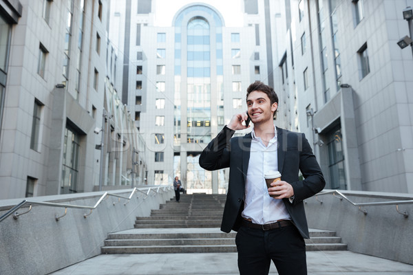 Businessman holding coffee and phone Stock photo © deandrobot