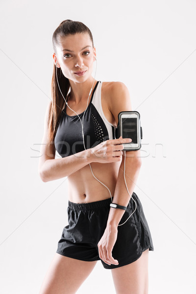 Porträt lächelnd Fitness Frau Sportbekleidung Musik hören Kopfhörer Stock foto © deandrobot