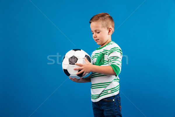 Portrait of a little kid looking and holding soccer ball Stock photo © deandrobot