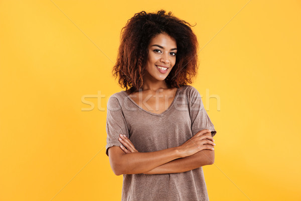 Smiling african woman posing with crossed arms looking at camera Stock photo © deandrobot