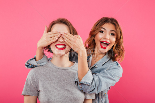 Two ladies friends covering eyes with hands. Stock photo © deandrobot