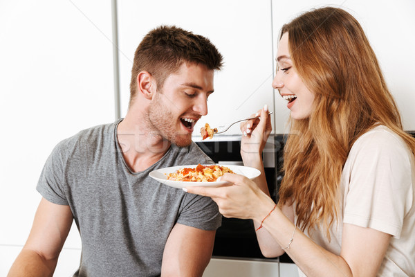 Cheerful young couple feeding each other with breakfast Stock photo © deandrobot