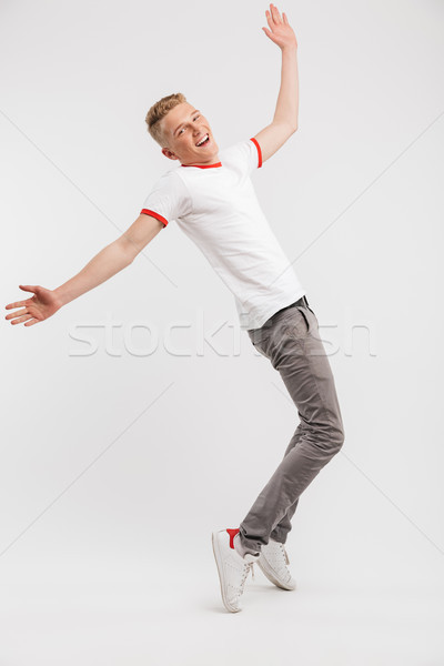 Full length portrait of cheerful teen man wearing casual clothin Stock photo © deandrobot