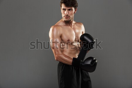 Naked sportsman boxing with his hands wrapped with elastic bandage on gray background Stock photo © deandrobot