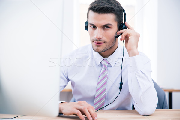 Male operator sitting at his workplace in office Stock photo © deandrobot