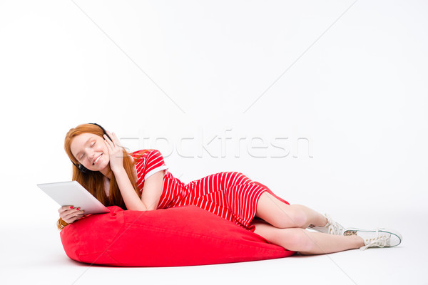 Content relaxed girl listening to music from tablet  Stock photo © deandrobot