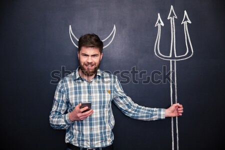 Flirty woman standing and winking over chalkboard background  Stock photo © deandrobot