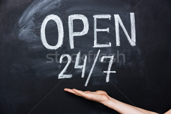 Hand showing open all the time sign drawn on blackboard Stock photo © deandrobot
