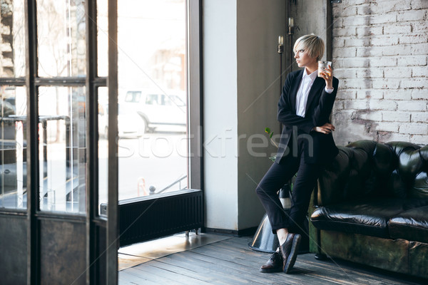 Stylish blonde girl standing in a cafe  Stock photo © deandrobot