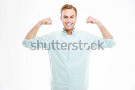 Portré derűs lezser férfi mutat bicepsz Stock fotó © deandrobot