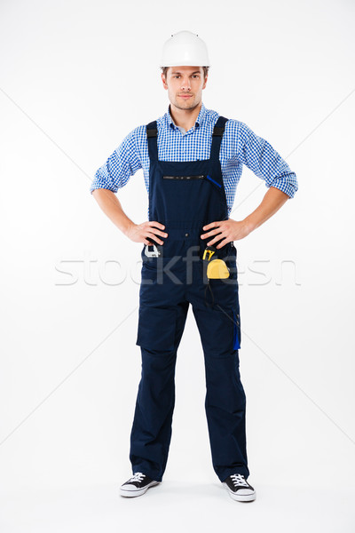 Full length of confident young man builder in helmet standing Stock photo © deandrobot