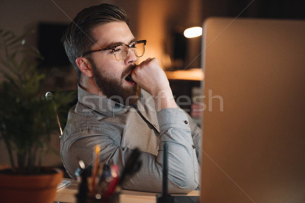 Tired web designer working late at night and yawning. Stock photo © deandrobot