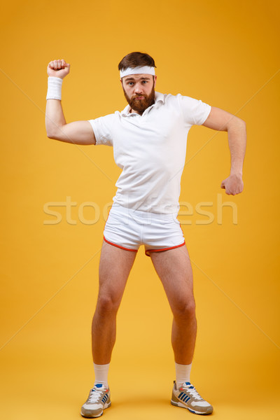 Vertical image of funny sportsman moving in stuio Stock photo © deandrobot