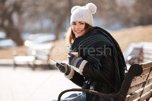 Szczęśliwy kobieta pitnej kawy komórka parku Zdjęcia stock © deandrobot